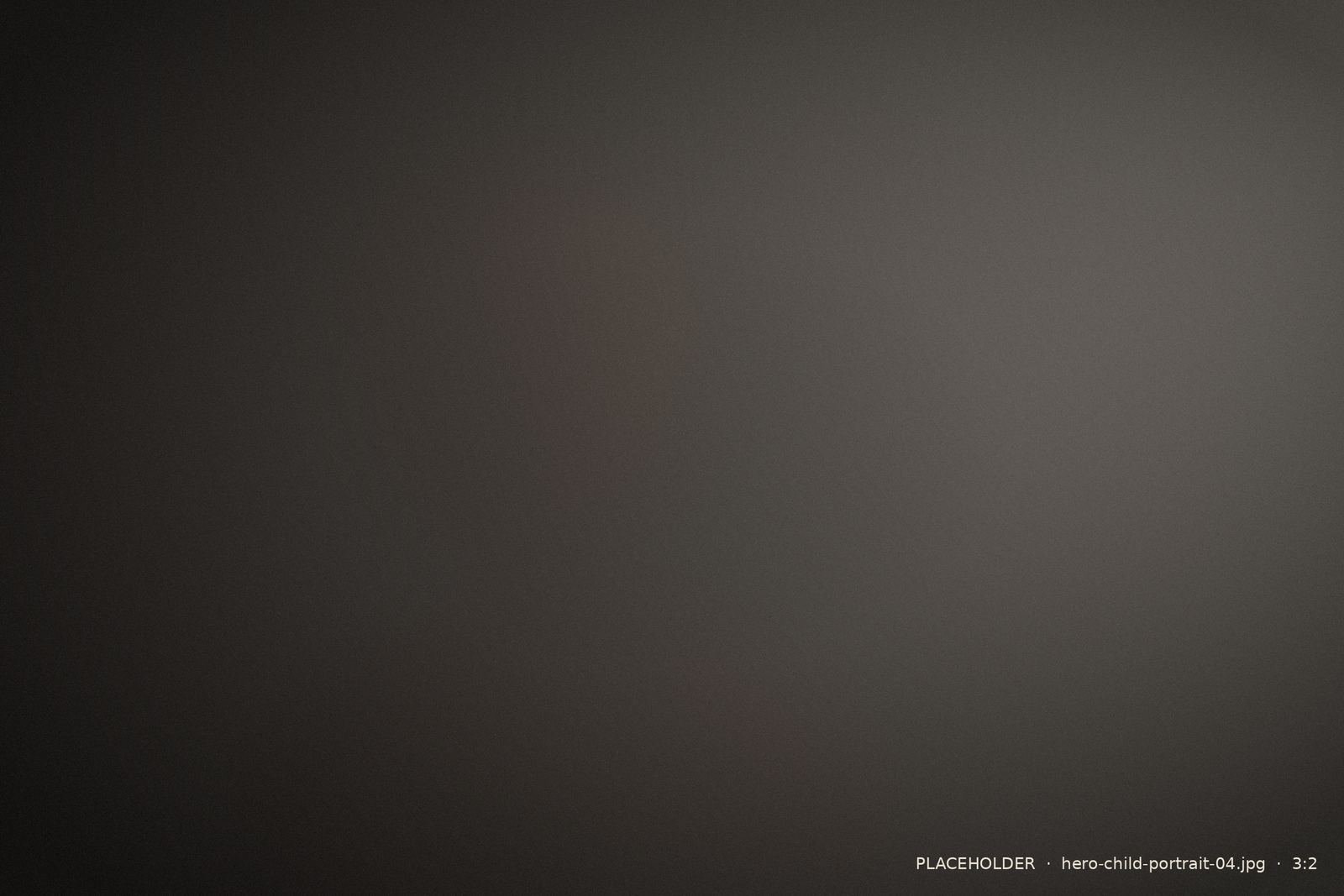 Understated child's portrait against a dark background
